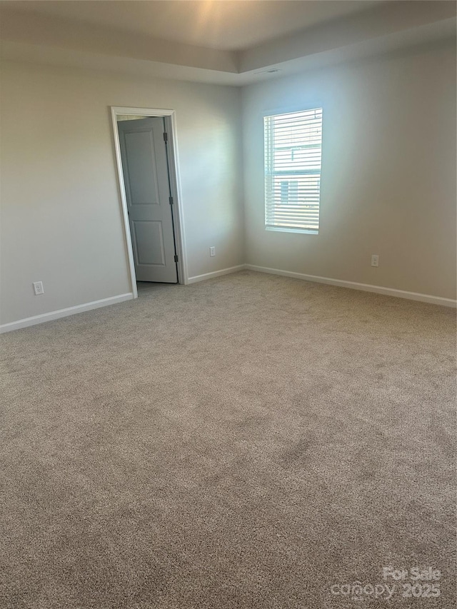 spare room with light carpet and baseboards