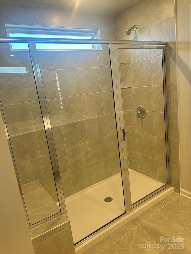 full bath with tile patterned flooring and a shower stall