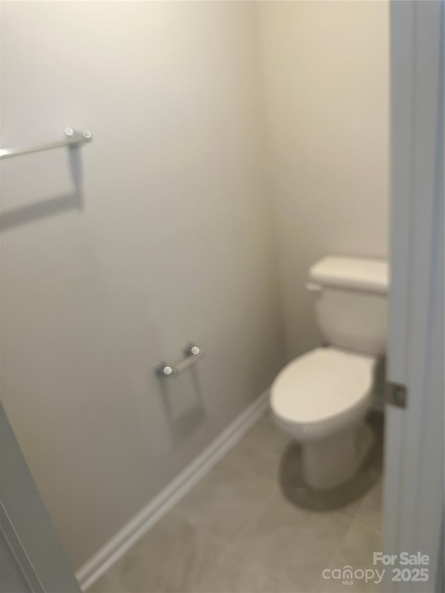 bathroom featuring tile patterned flooring, toilet, and baseboards