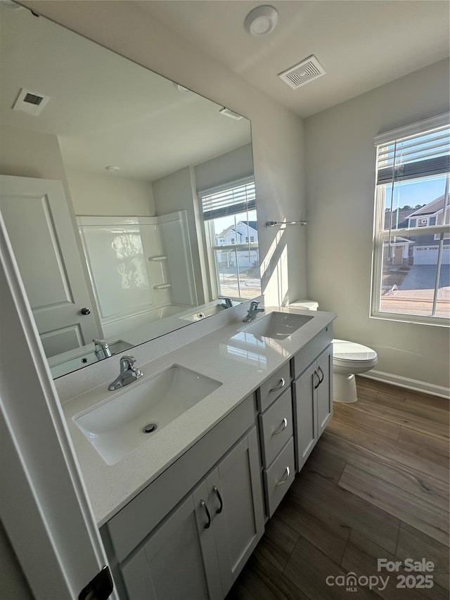 full bathroom featuring visible vents, a sink, and wood finished floors