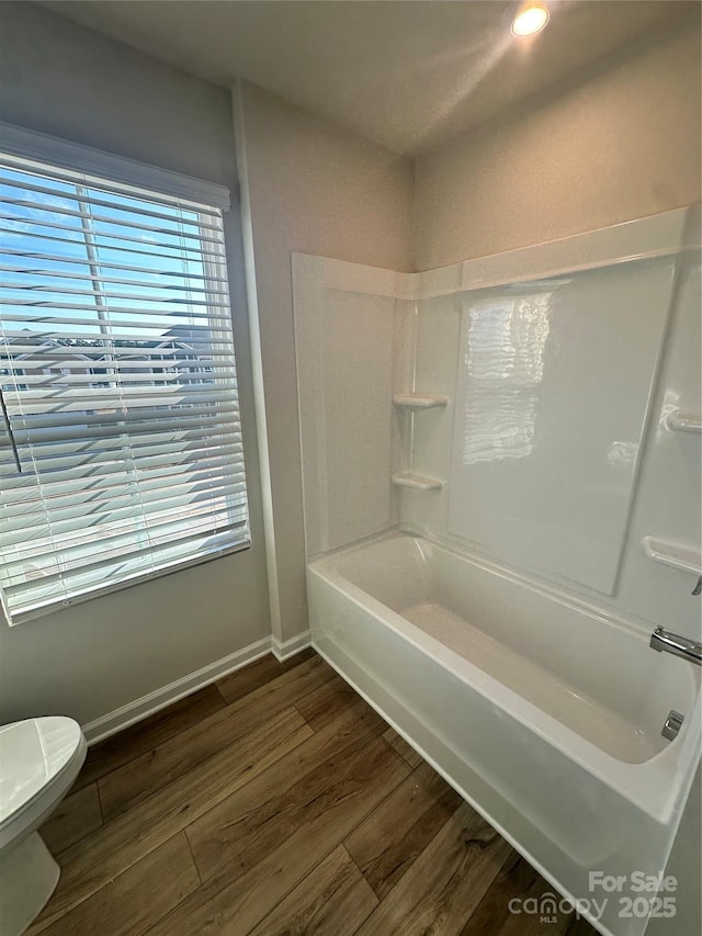 bathroom with  shower combination, baseboards, toilet, and wood finished floors