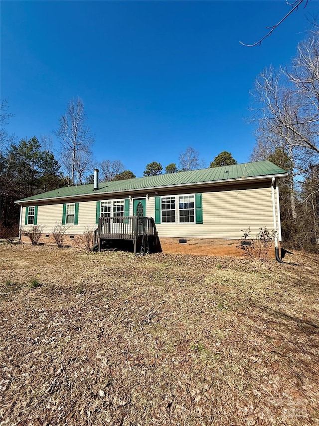 view of front of house with a deck, metal roof, and crawl space