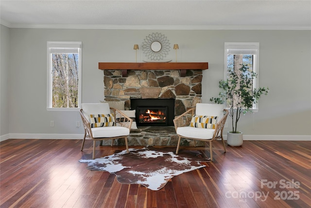 sitting room with wood-type flooring, a fireplace, baseboards, and crown molding