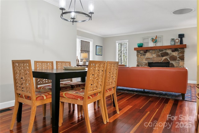 164 Waldsi Ct, Brevard, NC 28712 - dining area featuring a chandelier, ornamental molding, dark wood-style flooring, and a stone fireplace