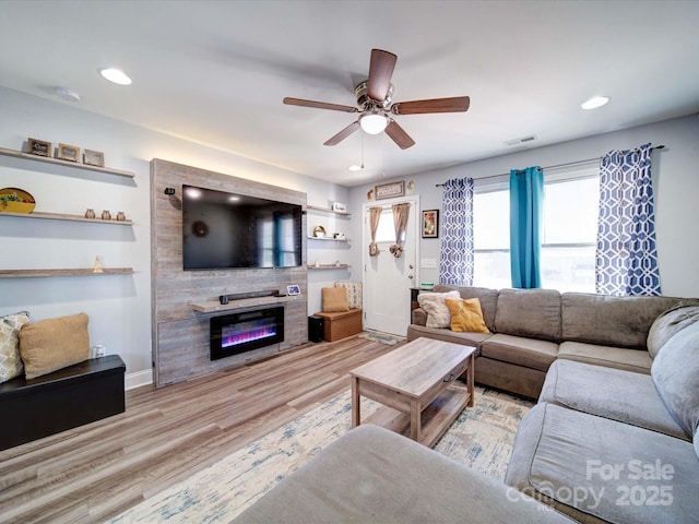 living room with a large fireplace, visible vents, light wood-style flooring, ceiling fan, and recessed lighting