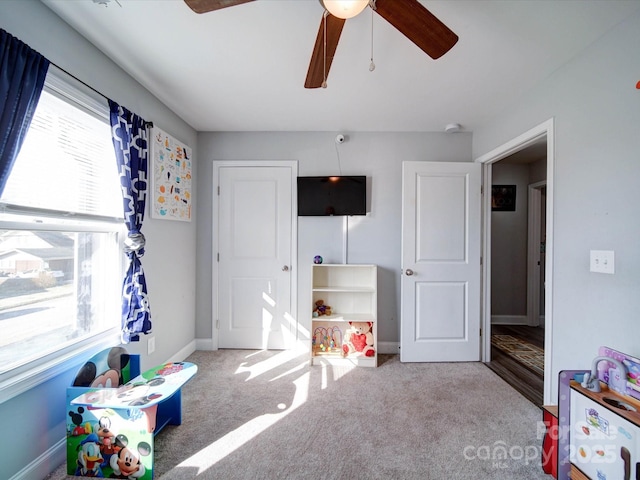 game room featuring light carpet, ceiling fan, and baseboards