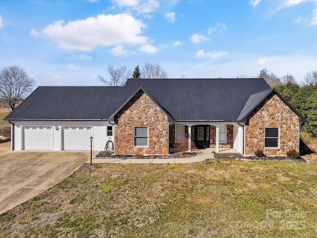 single story home with concrete driveway, metal roof, a front lawn, and an attached garage