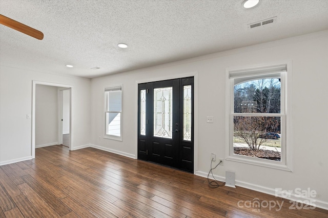 entryway featuring plenty of natural light, visible vents, dark wood finished floors, and baseboards