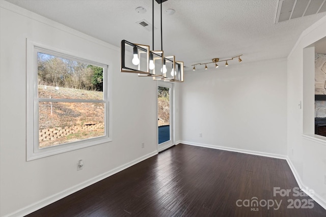 unfurnished dining area with baseboards, a textured ceiling, visible vents, and dark wood-style flooring