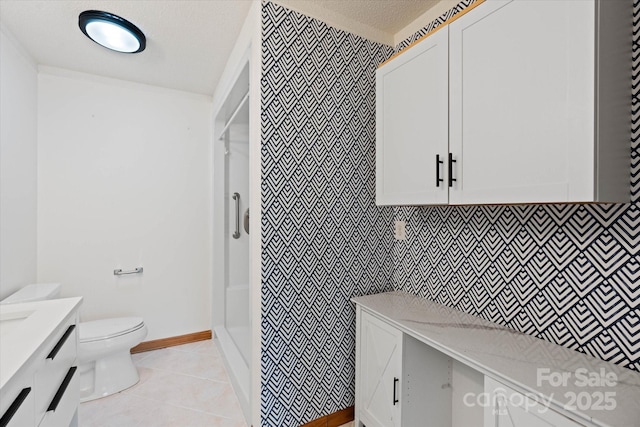 full bathroom with a textured ceiling, a walk in shower, toilet, vanity, and tile patterned floors