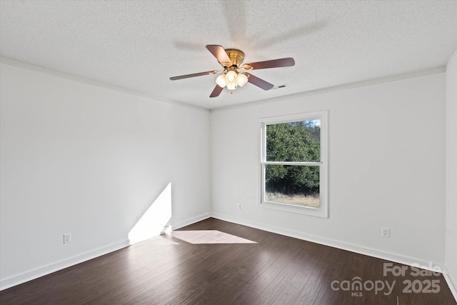 spare room with baseboards, dark wood finished floors, and a textured ceiling