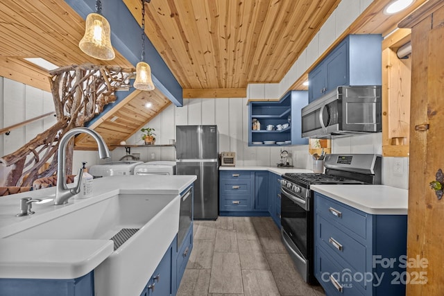 kitchen featuring blue cabinets, light countertops, appliances with stainless steel finishes, open shelves, and washer and clothes dryer