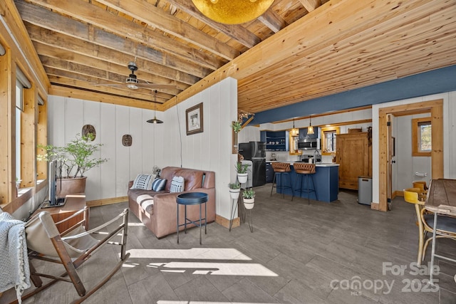 living room featuring baseboards, a ceiling fan, wooden ceiling, wood finished floors, and beam ceiling