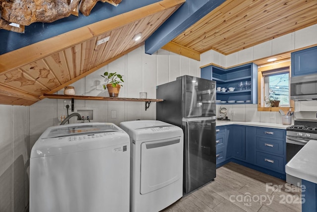 clothes washing area featuring wooden ceiling, wood tiled floor, and washer and dryer