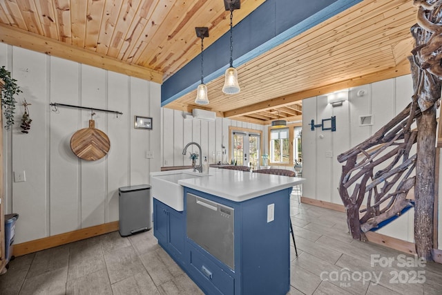 kitchen with hanging light fixtures, a kitchen island with sink, a sink, blue cabinets, and wooden ceiling