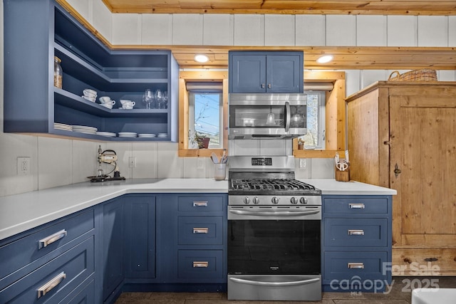 kitchen with appliances with stainless steel finishes, blue cabinets, light countertops, and open shelves