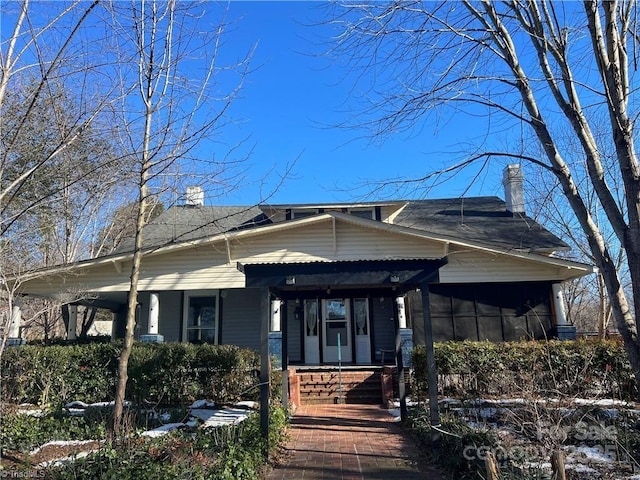 bungalow featuring a porch and a chimney