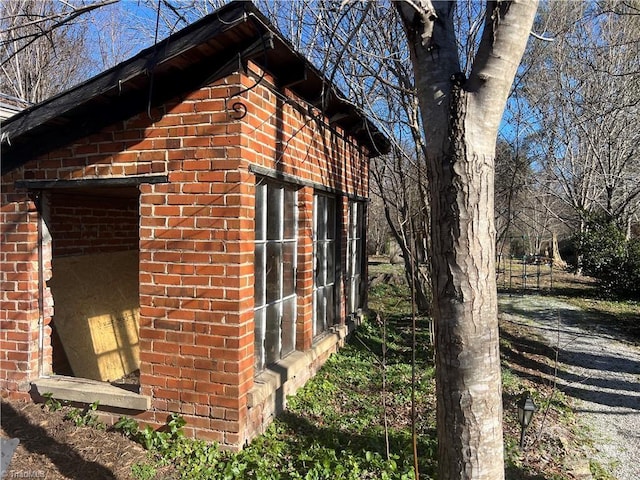 view of property exterior with an outbuilding and brick siding