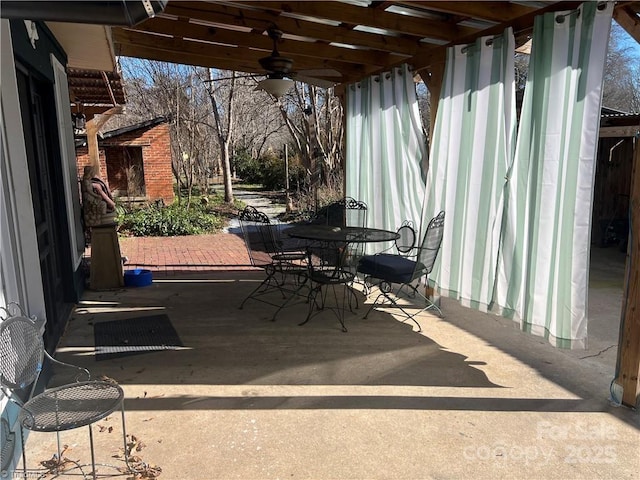 view of patio / terrace with outdoor dining space, a fireplace, and ceiling fan