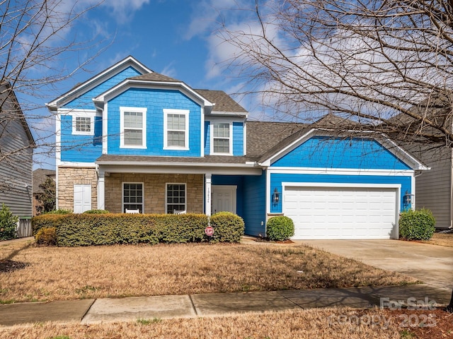 traditional-style house with stone siding, concrete driveway, and a garage