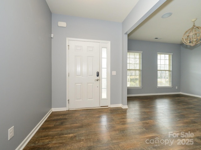 foyer with dark wood-style floors, visible vents, and baseboards