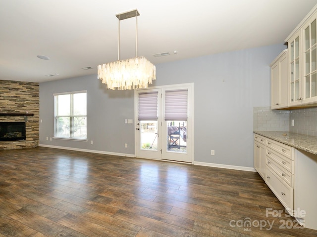 kitchen with open floor plan, tasteful backsplash, dark wood-style flooring, and a fireplace