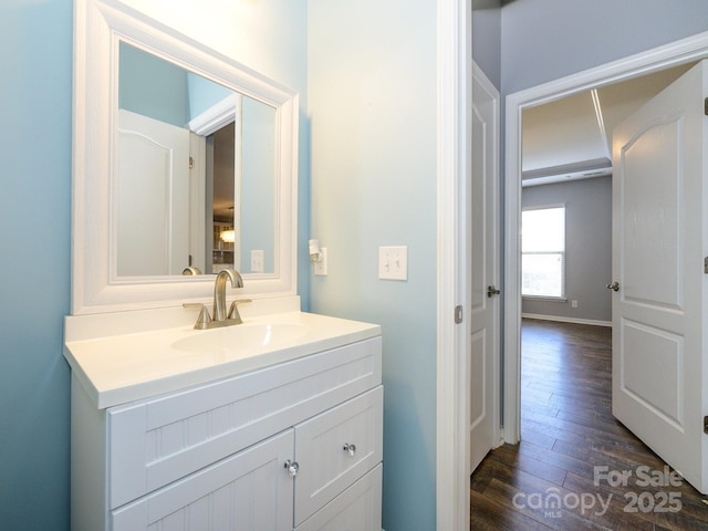 bathroom featuring baseboards, wood finished floors, and vanity