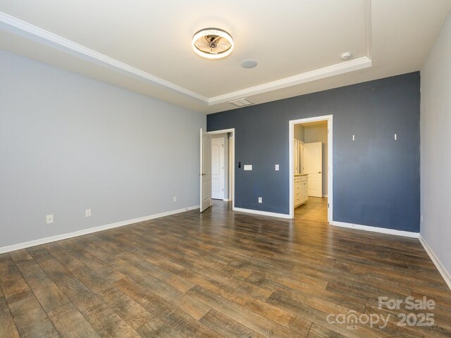 unfurnished room with dark wood-style floors, visible vents, and baseboards