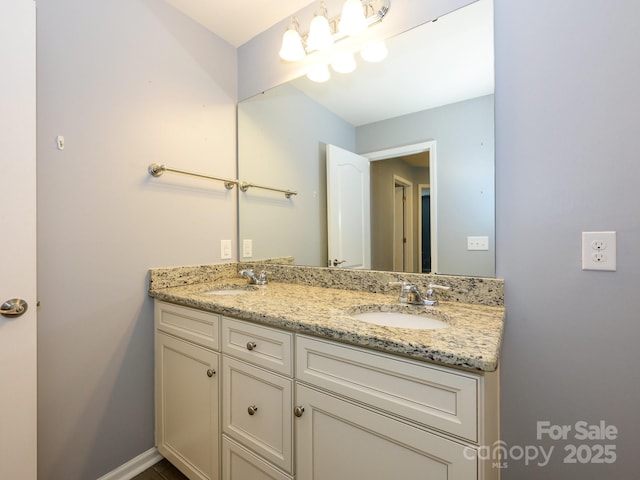 bathroom featuring double vanity, baseboards, and a sink