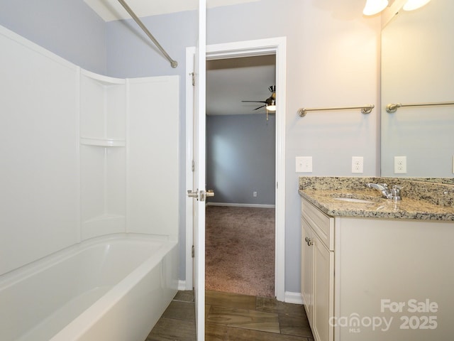 bathroom with a ceiling fan, baseboards, shower / tub combination, and vanity