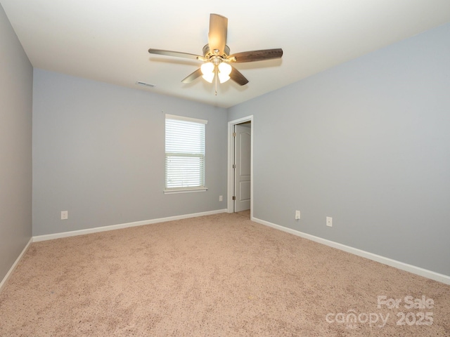 carpeted empty room with a ceiling fan, baseboards, and visible vents