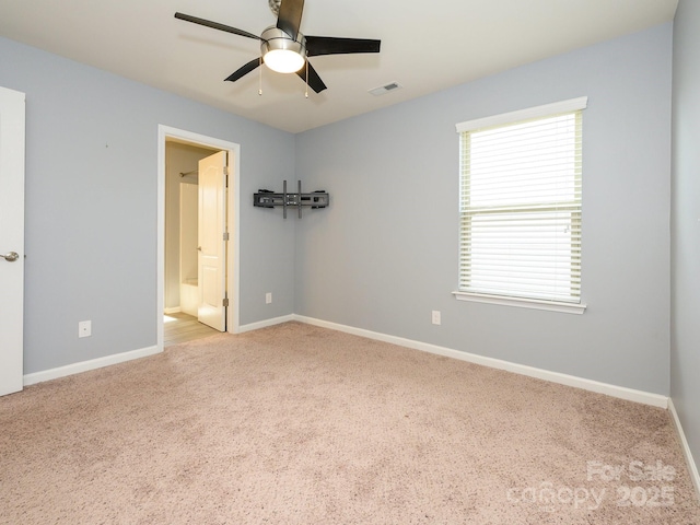 spare room featuring carpet flooring, baseboards, visible vents, and ceiling fan