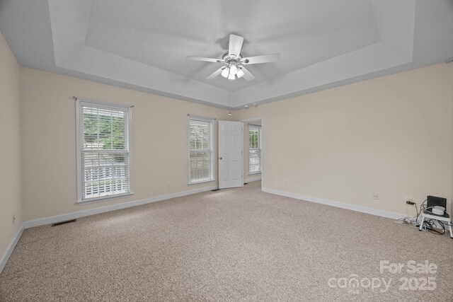 3039 Paraham Rd S, York, SC 29745 - empty room featuring a raised ceiling, ceiling fan, healthy amount of natural light, and light carpet