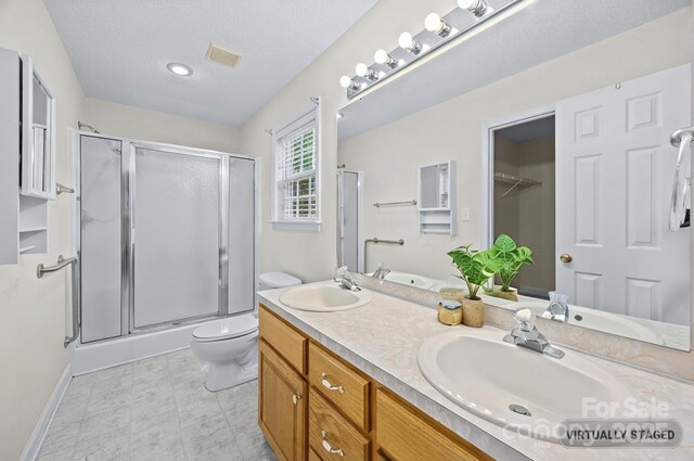 3039 Paraham Rd S, York, SC 29745 - bathroom featuring double vanity, a shower stall, toilet, a textured ceiling, and tile patterned floors