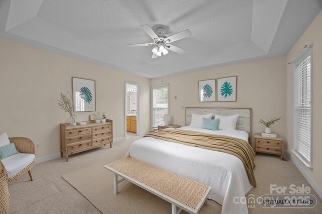 3039 Paraham Rd S, York, SC 29745 - bedroom featuring light colored carpet, a tray ceiling, baseboards, connected bathroom, and ceiling fan