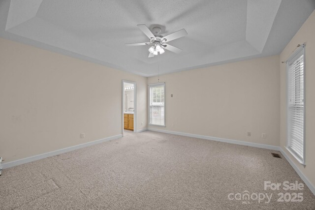 3039 Paraham Rd S, York, SC 29745 - unfurnished bedroom with light colored carpet, baseboards, a raised ceiling, a textured ceiling, and ensuite bathroom