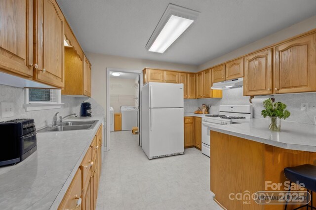 3039 Paraham Rd S, York, SC 29745 - kitchen featuring white appliances, separate washer and dryer, under cabinet range hood, a sink, and light countertops