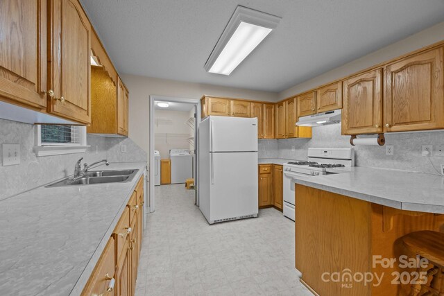 3039 Paraham Rd S, York, SC 29745 - kitchen featuring white appliances, independent washer and dryer, under cabinet range hood, light floors, and light countertops
