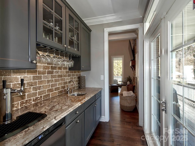 bar featuring ornamental molding, backsplash, dark wood-type flooring, a sink, and indoor wet bar