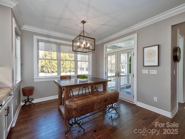 dining room with dark wood-style flooring, french doors, ornamental molding, a chandelier, and baseboards