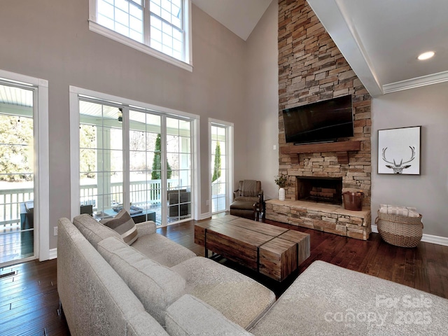 living area with dark wood finished floors, a fireplace, recessed lighting, high vaulted ceiling, and baseboards