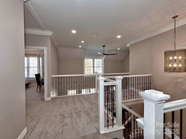 hall with a healthy amount of sunlight, ornamental molding, and an upstairs landing