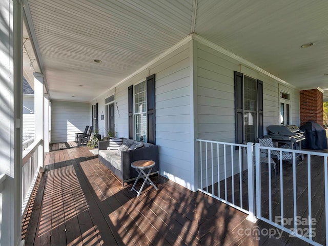 wooden deck with a porch and area for grilling