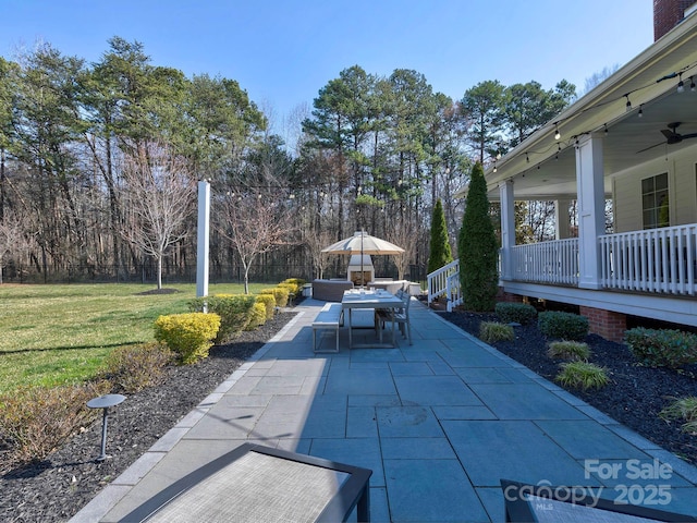 view of home's community featuring outdoor dining area, a lawn, and a patio area