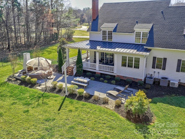 back of property with central air condition unit, a shingled roof, crawl space, a patio area, and a standing seam roof