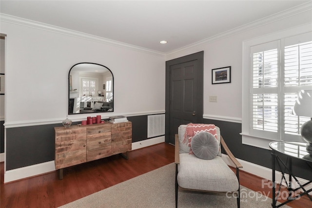 living area with ornamental molding, plenty of natural light, wood finished floors, and baseboards