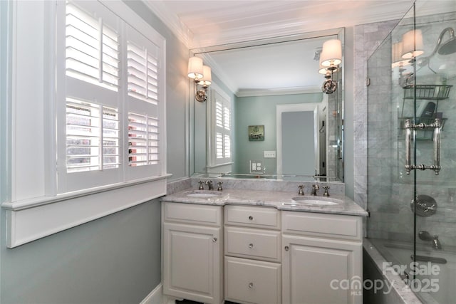 full bath with double vanity, ornamental molding, bath / shower combo with glass door, and a sink