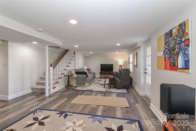 living room featuring stairs, baseboards, wood finished floors, and recessed lighting