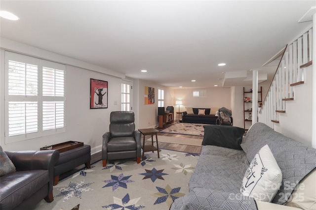 living room featuring baseboards, stairway, and recessed lighting