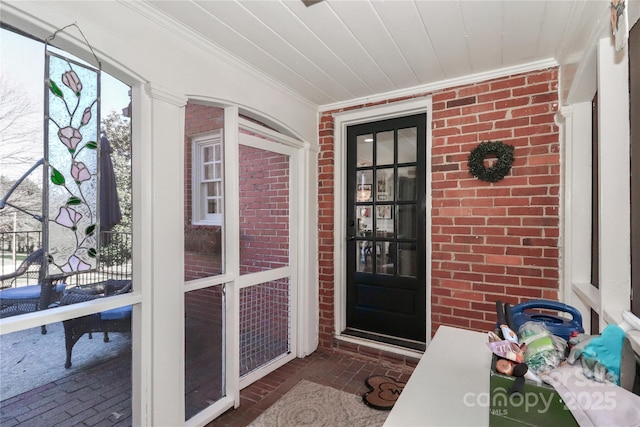 property entrance with covered porch and brick siding